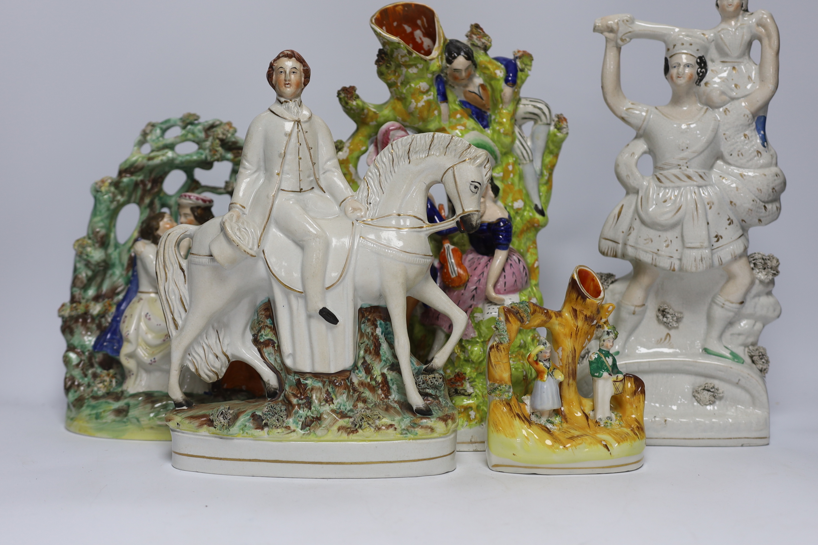 Seven Staffordshire flat backs, including a gentleman on horse back, two seated lovers, a similar pair of King Charles Spaniels, and a pair of Staffordshire style cats, tallest 32cm